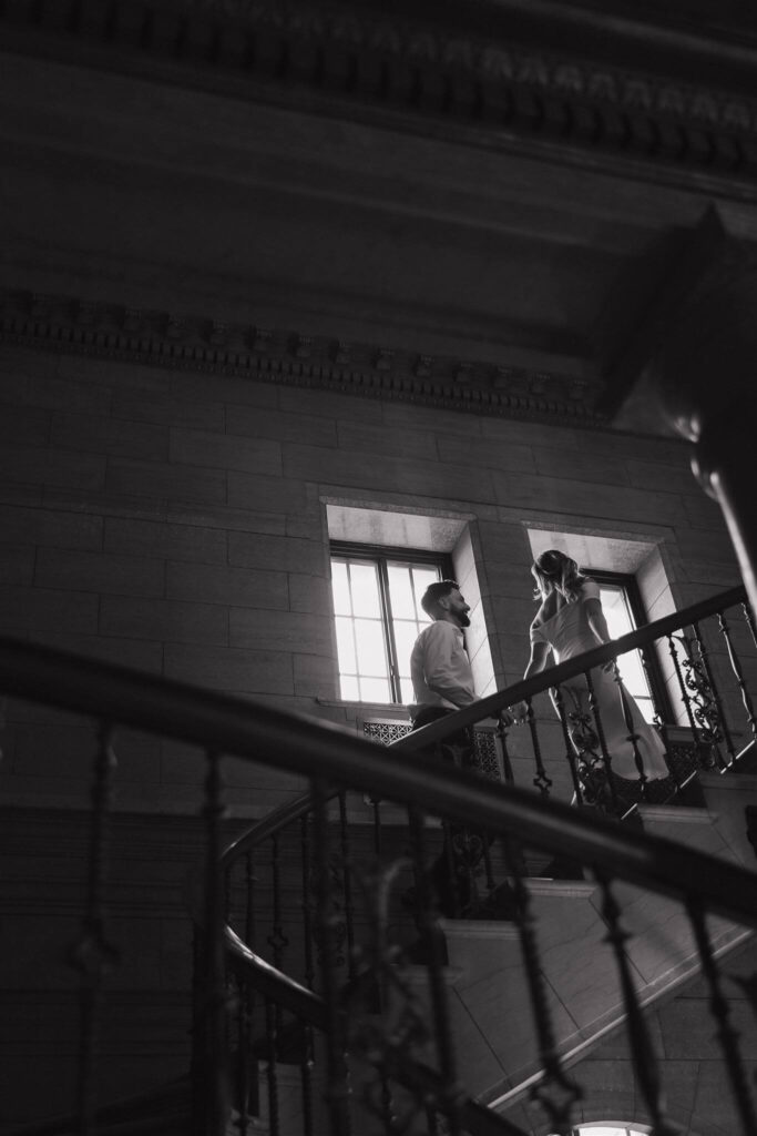 Couple walks up the stairwell in engagement photos