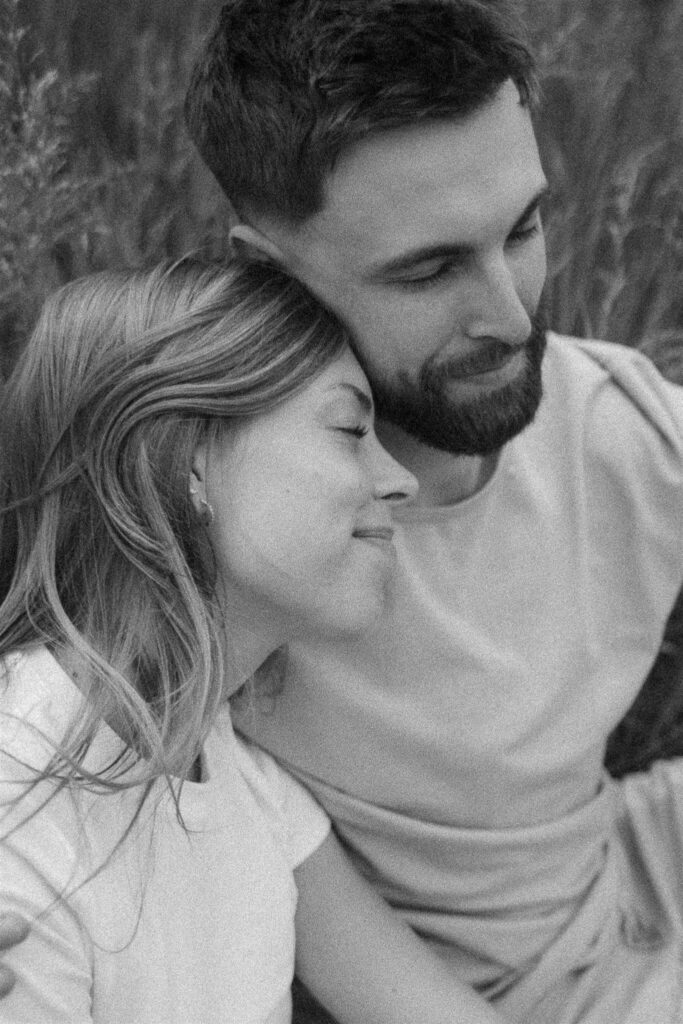 Woman leans her head on her fiance's shoulder during their engagement photos