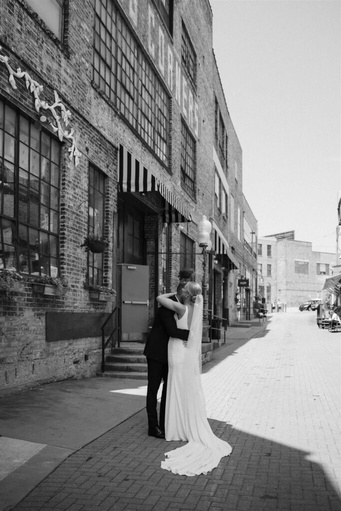 Bride and groom hug outside Bar Lurcat in downtown Minneapolis