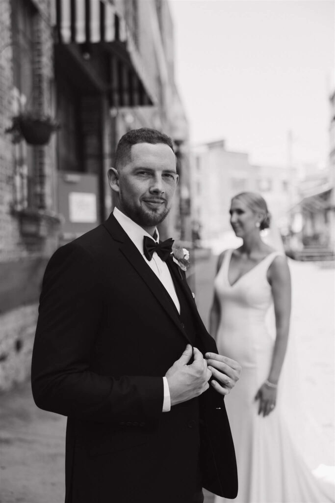 Groom looks at the camera while bride looks off in the distance at microwedding in downtown Minneapolis