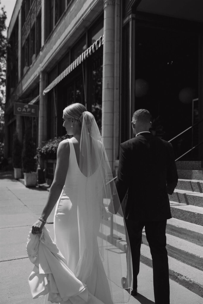 Bride and groom walk hand in hand through downtown Minneapolis