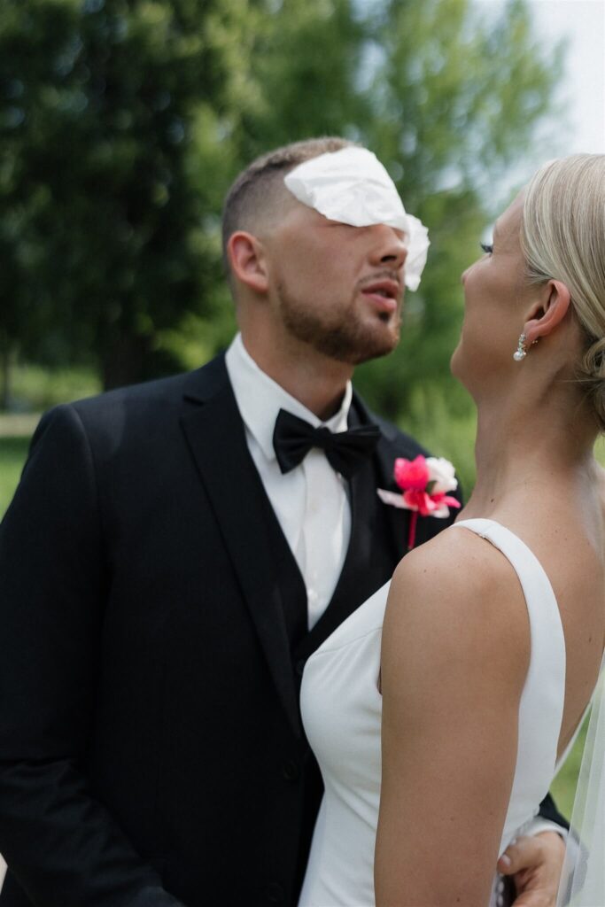 Bride places kleenex on groom's head to wipe his sweat