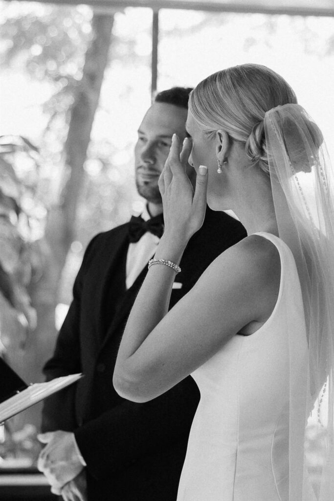 Bride wipes her tears during microwedding ceremony