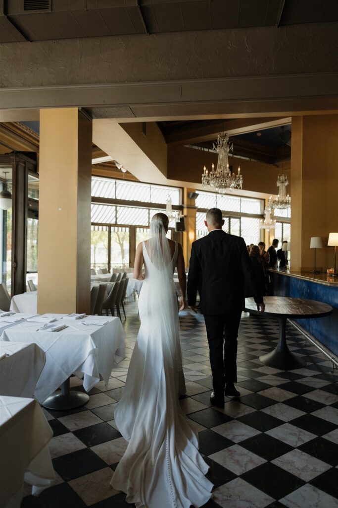 Bride and groom walk hand in hand through Bar Lurcat in downtown Minneapolis