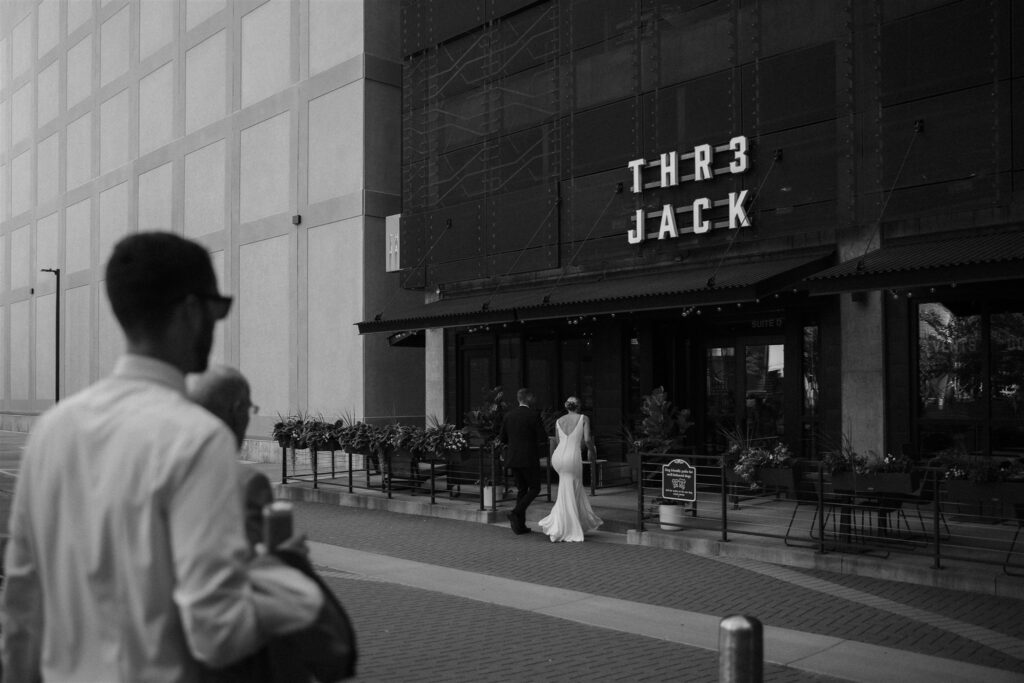 Bride, groom, and wedding guests walk into Thr3 Jack in Minneapolis