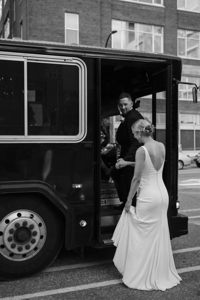 Groom helps his bride up onto the party bus