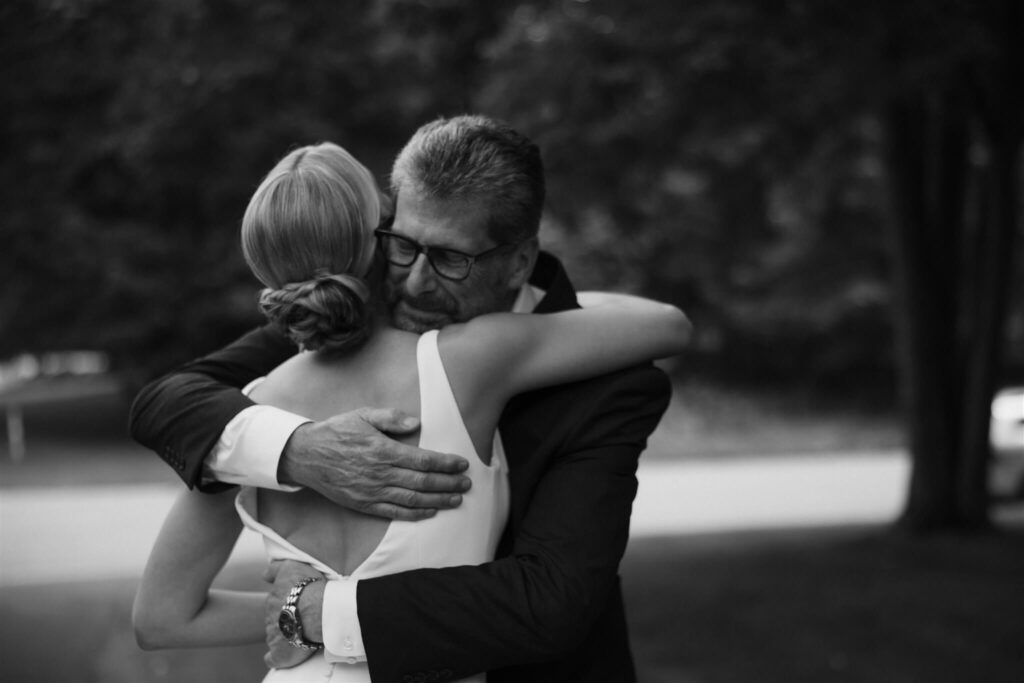 Father of the bride hugs bride in emotional microwedding first look