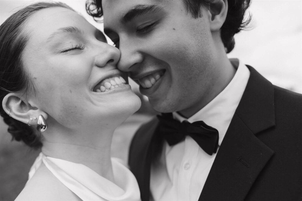 Bride and groom grin while touching noses