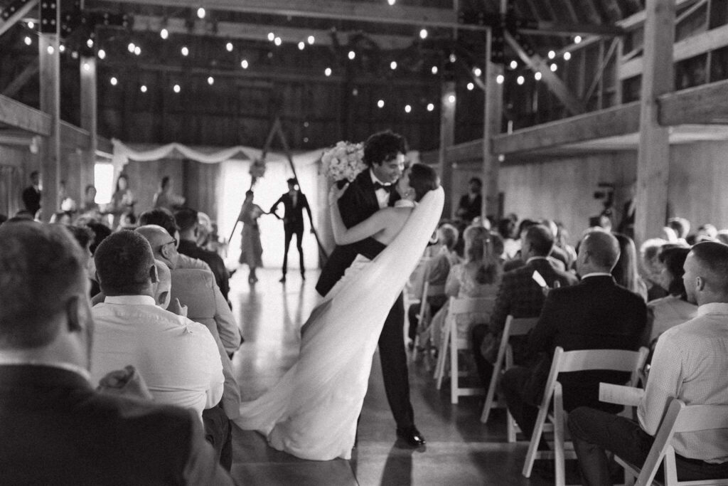 Groom dips bride to the ground during their walk back down the aisle as husband and wife