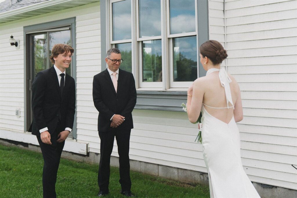 Father of the bride and brother of the bride see bride for the first time in her classic wedding gown