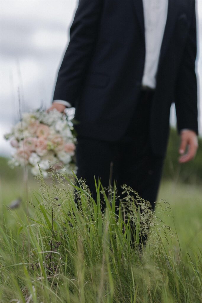 Groom holds bride's bouquet