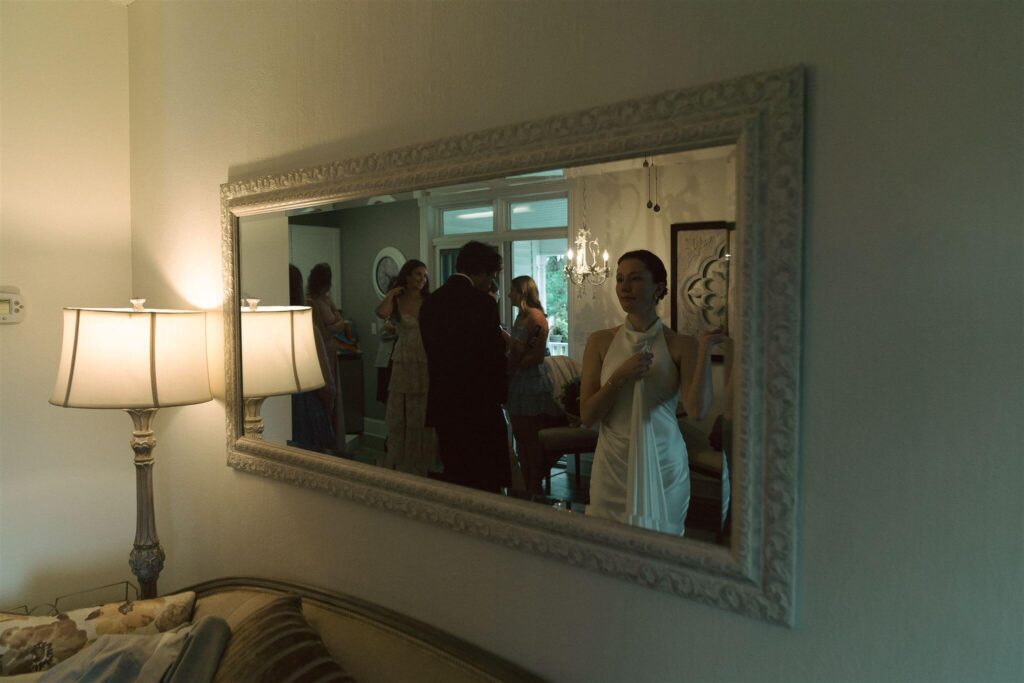 Bride fixes her dress in vintage mirror