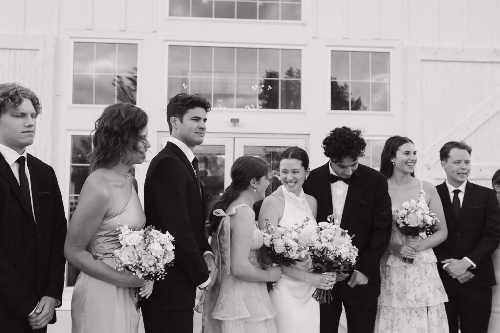 Bride and groom laugh with members of their wedding party