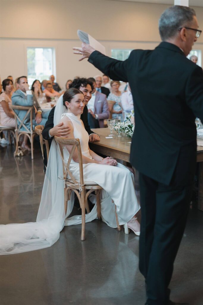 Bride and groom listen to father of the bride's wedding speech