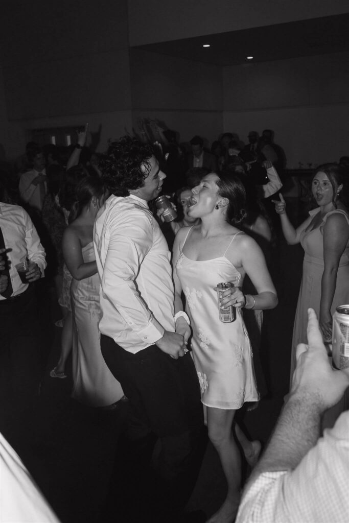 Bride and groom dance in each other's arms at energetic wedding reception