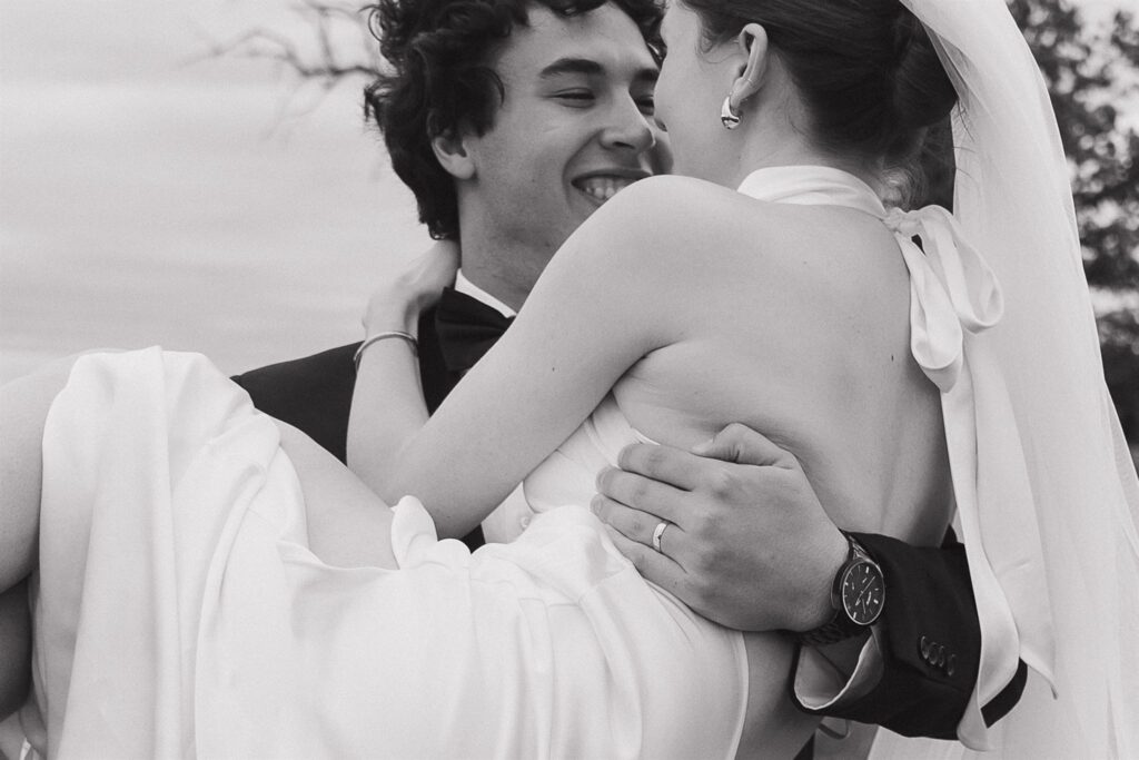 Groom holds bride in his arms