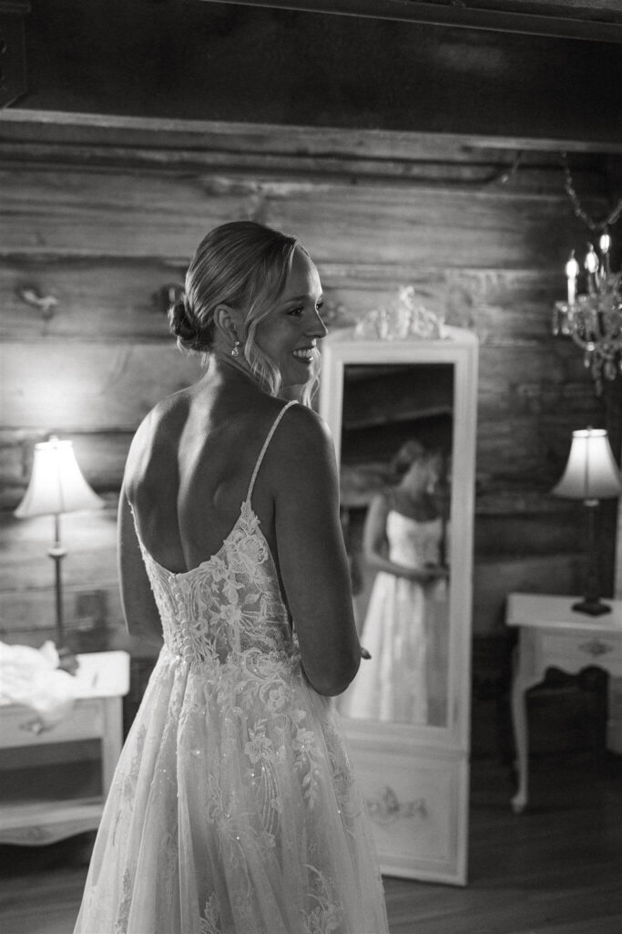 Bride smiles over her shoulder at farm wedding venue