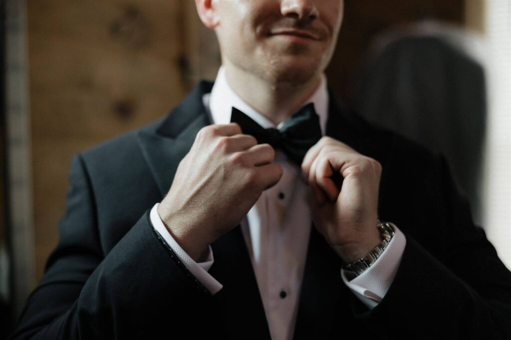 Groom straightens his bow tie