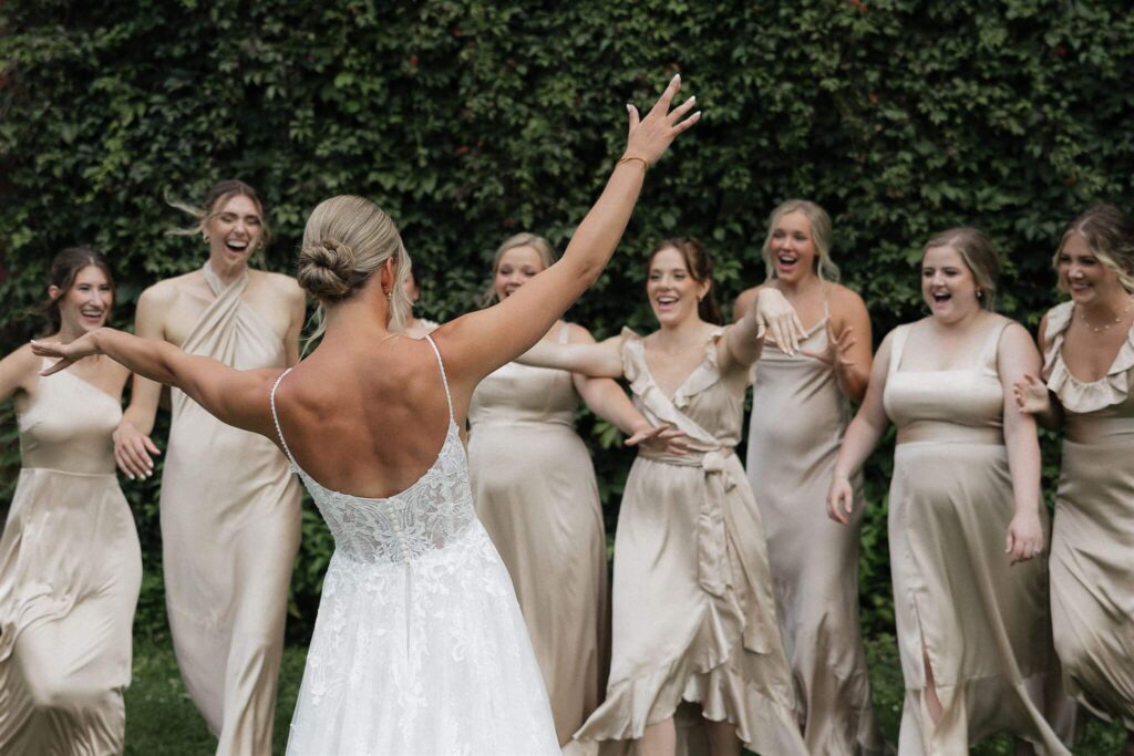 Bride and her bridesmaids celebrate during her first look at farm wedding venue in Minneapolis