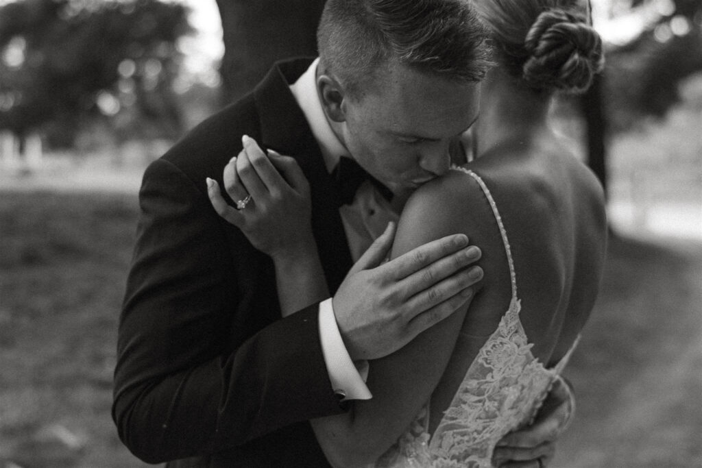 Groom tenderly kisses bride's shoulder