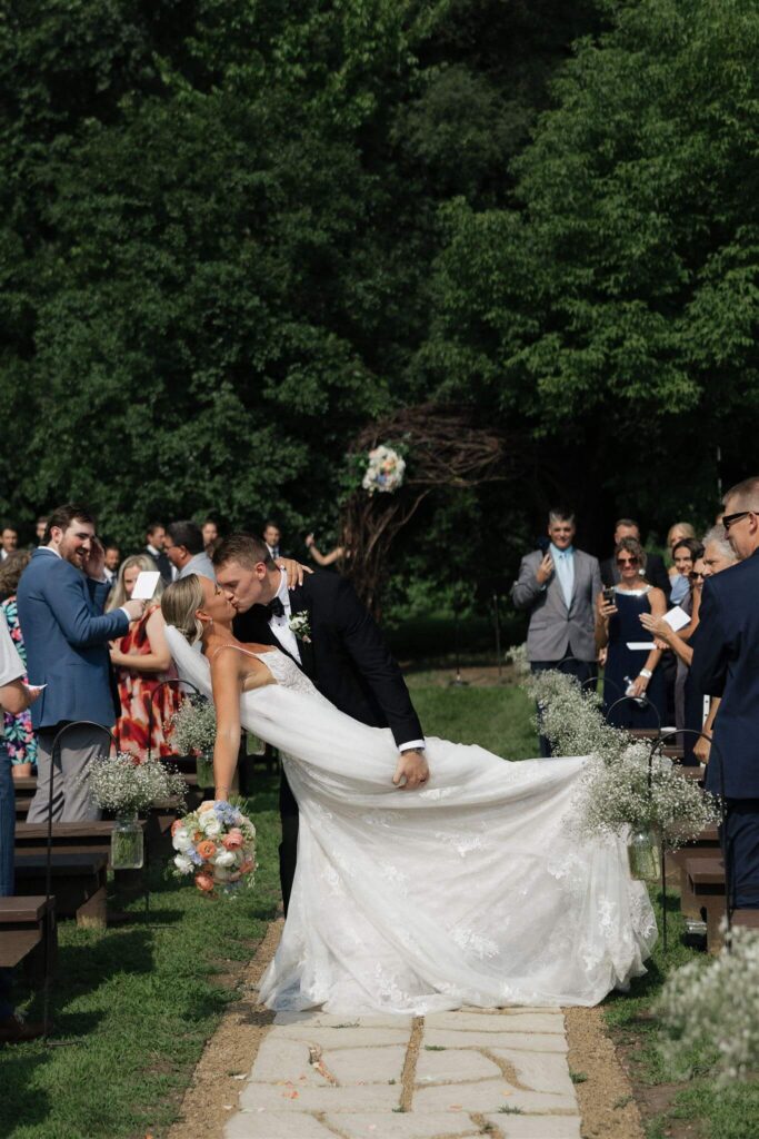 Groom dips his bride to the ground in first kiss as husband and wife