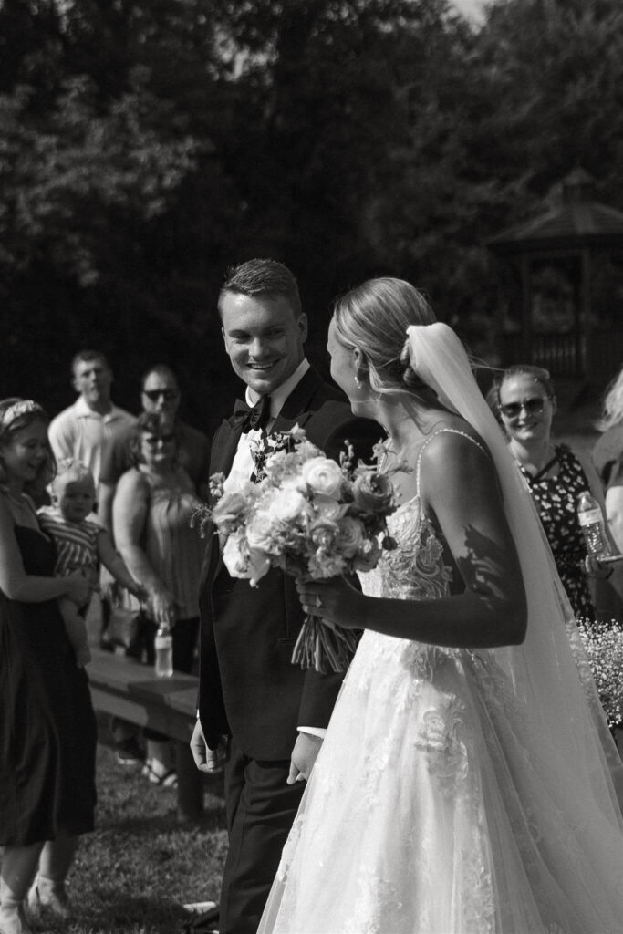 Bride and groom smile at each other as they exit their ceremony