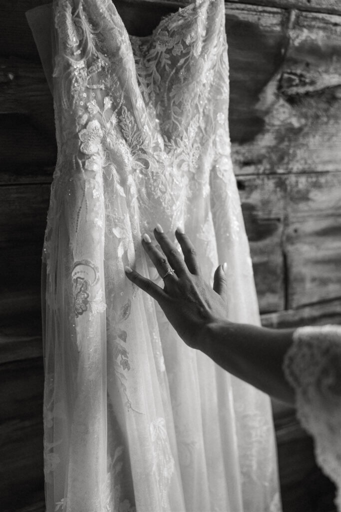 Bride gently touches her wedding gown