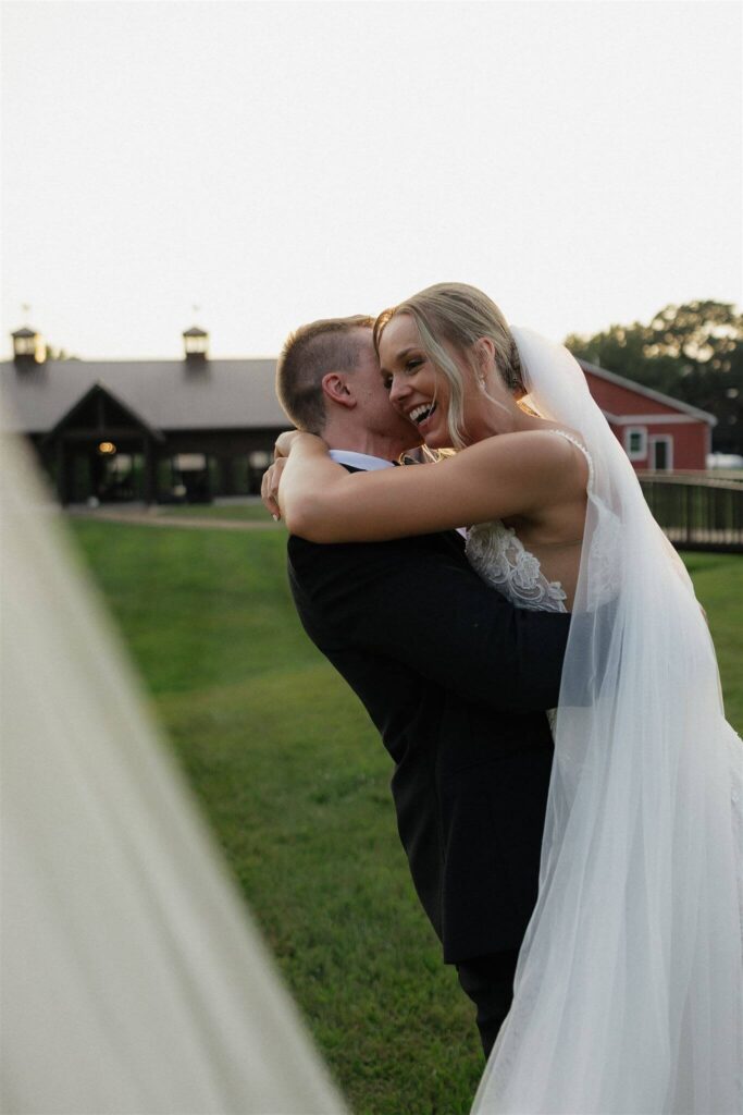 Groom lifts bride as she beams with delight at Hope Glen Farm wedding venue