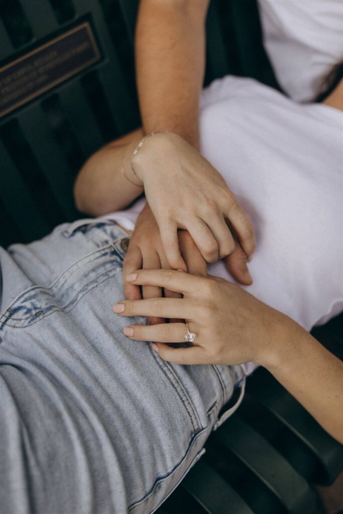 Man's hands lays tenderly on his fiance's stomach in engagement photo shoot