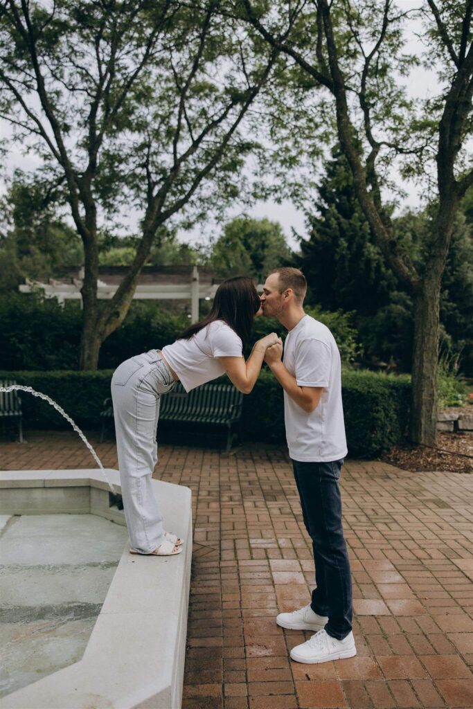 Woman leans down from ledge to kiss her fiance