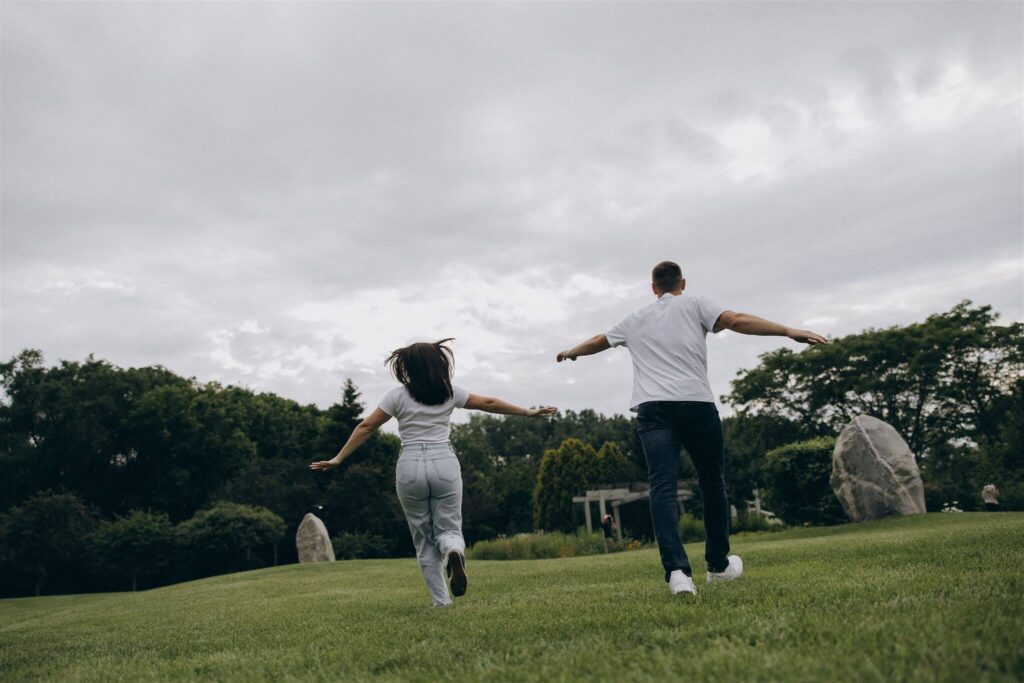 Man and woman in matching white tees and jeans run through St. Paul park together