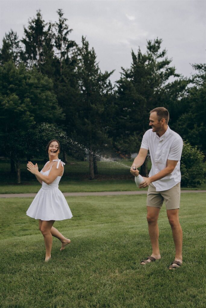 Engaged couple pops champagne in St Paul engagement photo shoot