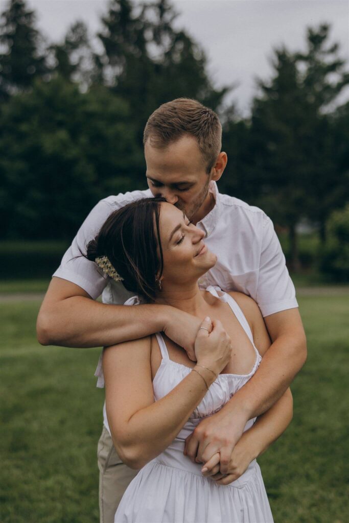 Man wraps his arms around his fiancee in St Paul engagement photo shoot