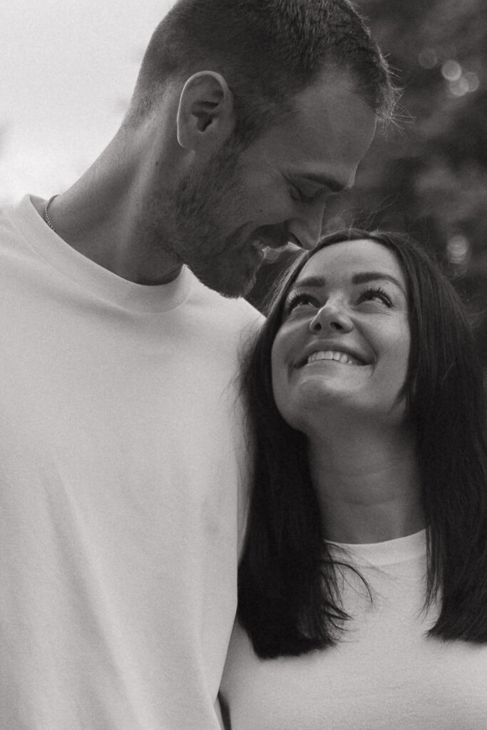 Woman smiles up at her fiance as he smiles back at her in Twin Cities engagement photo shoot 