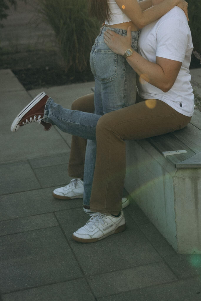 Man holds woman's waist in Minneapolis engagement photos