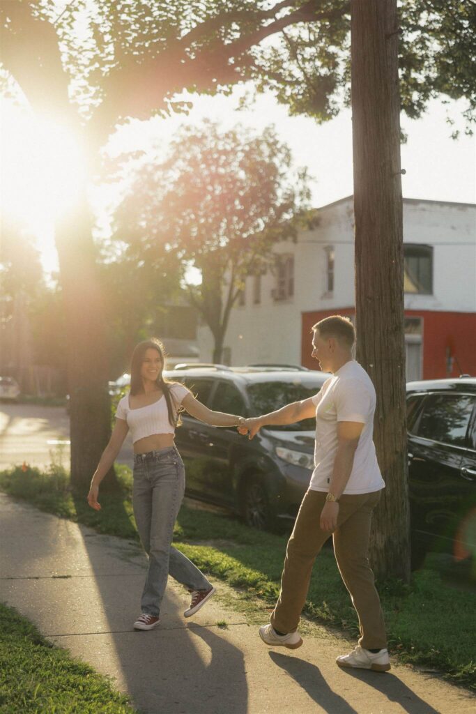 Man and woman walk hand in hand during engagement photoshoot in Minnesota