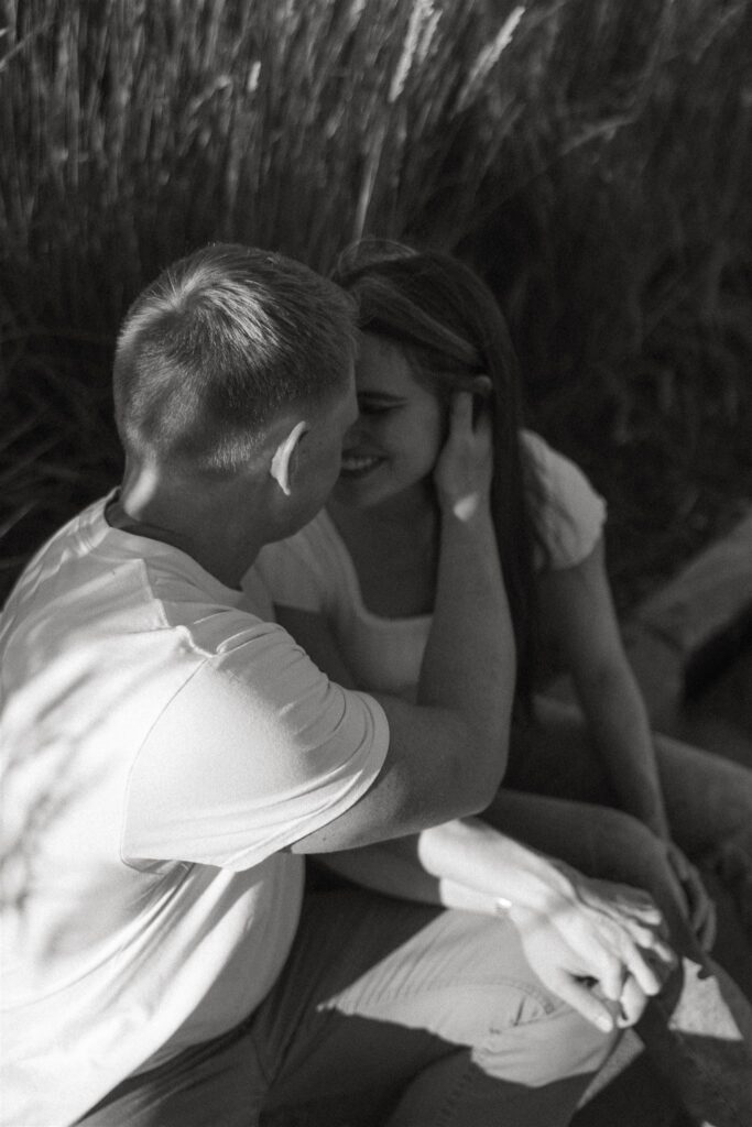 Man cups woman's face as he goes in for a soft kiss