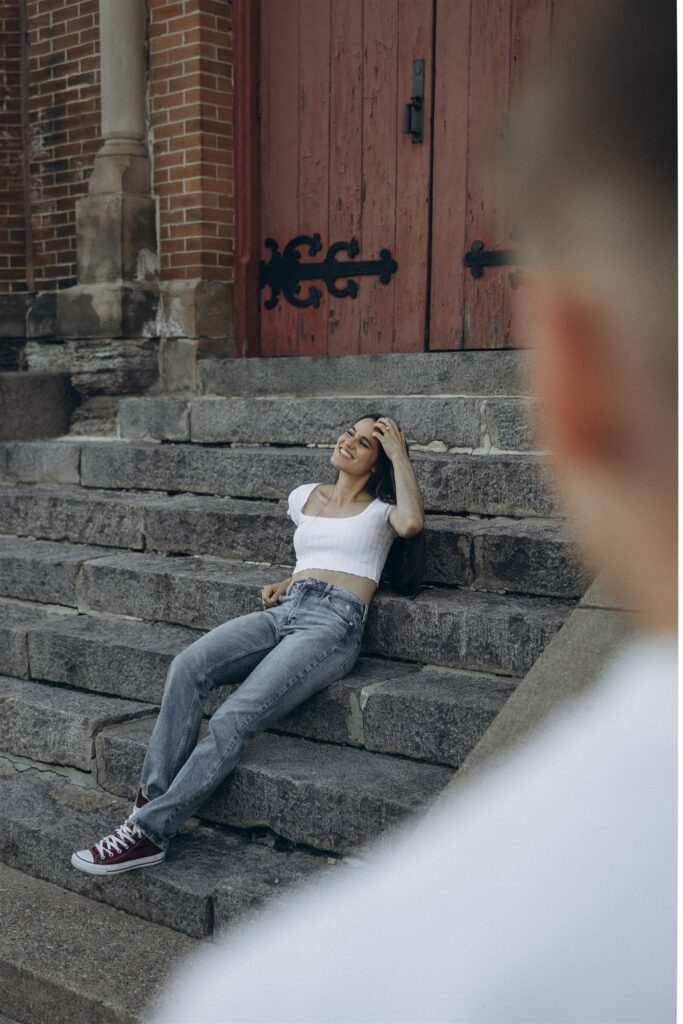 Man looks on as his fiance sits on historic building steps in Northeast Minneapolis