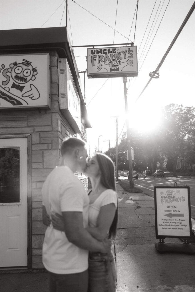 Engaged couple kisses outside of Uncle Franky's in Northeast Minneapolis