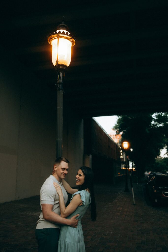 Engagement photography ideas for man and woman under streetlight glow