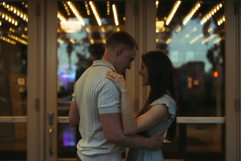 Engaged couple dances under the marquee lights in downtown Minneapolis