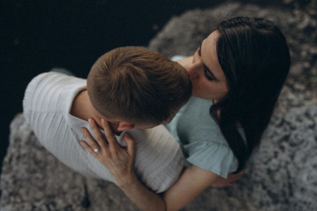 Woman kisses top of man's head in engagement photos in Minnesota