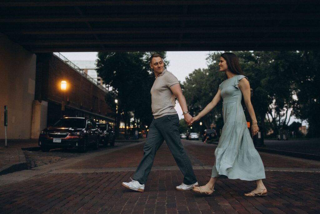 Engaged couple wanders through the streets of downtown Minneapolis for engagement photography ideas