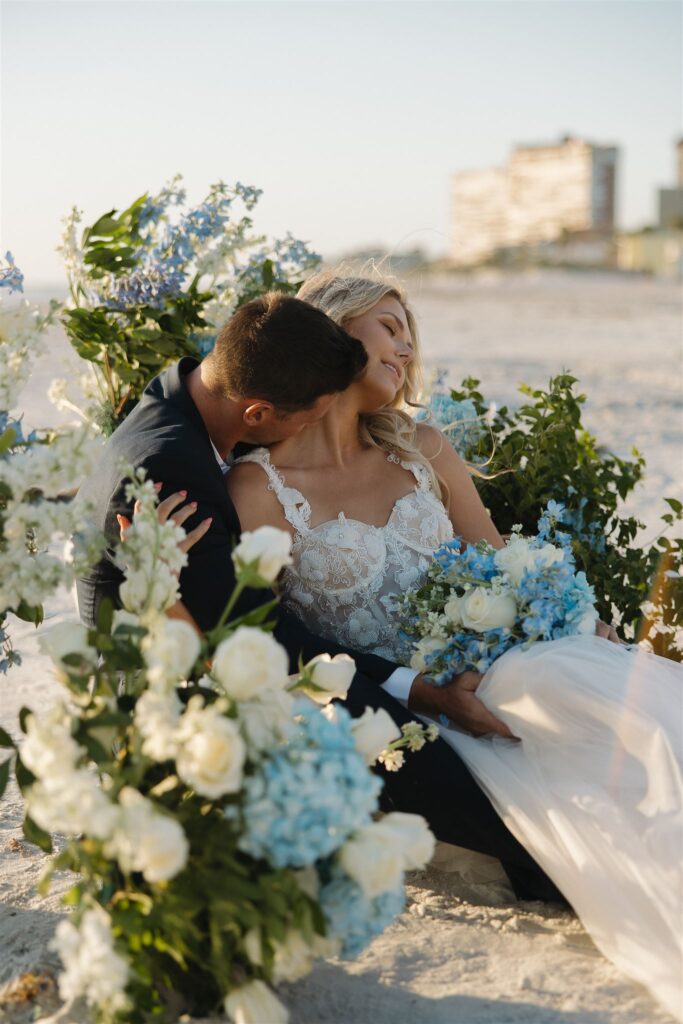 Stunning hydrangeas and roses surround bride and groom at their destination elopement on Florida beach