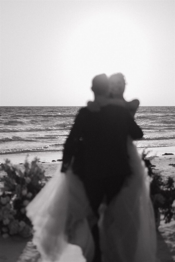 Groom carries bride off into the sunset of destination elopement in Florida