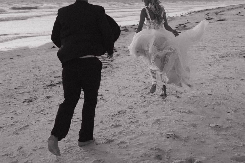 Newlyweds run through the sand during intimate destination elopement