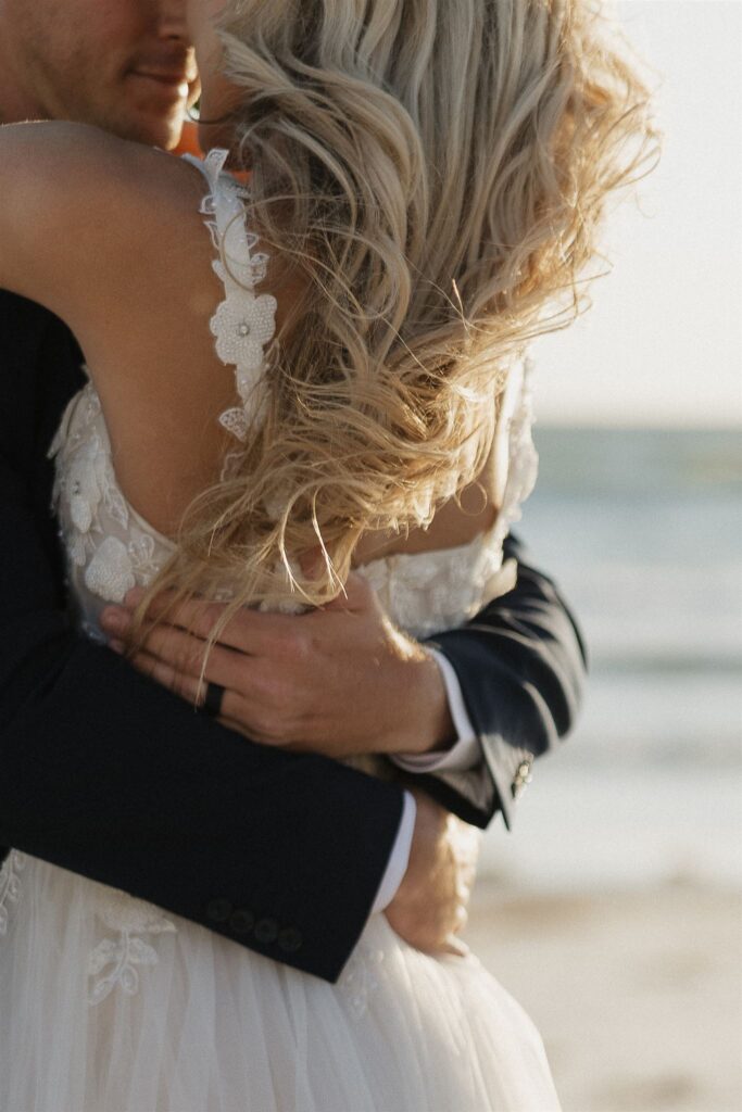 Groom's hands wrap around bride's waits in destination elopement embrace