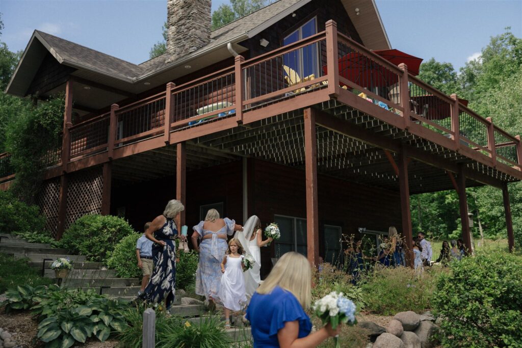 Bride and other women in the wedding party scatter on the steps of their cabin in Walker, Minnesota