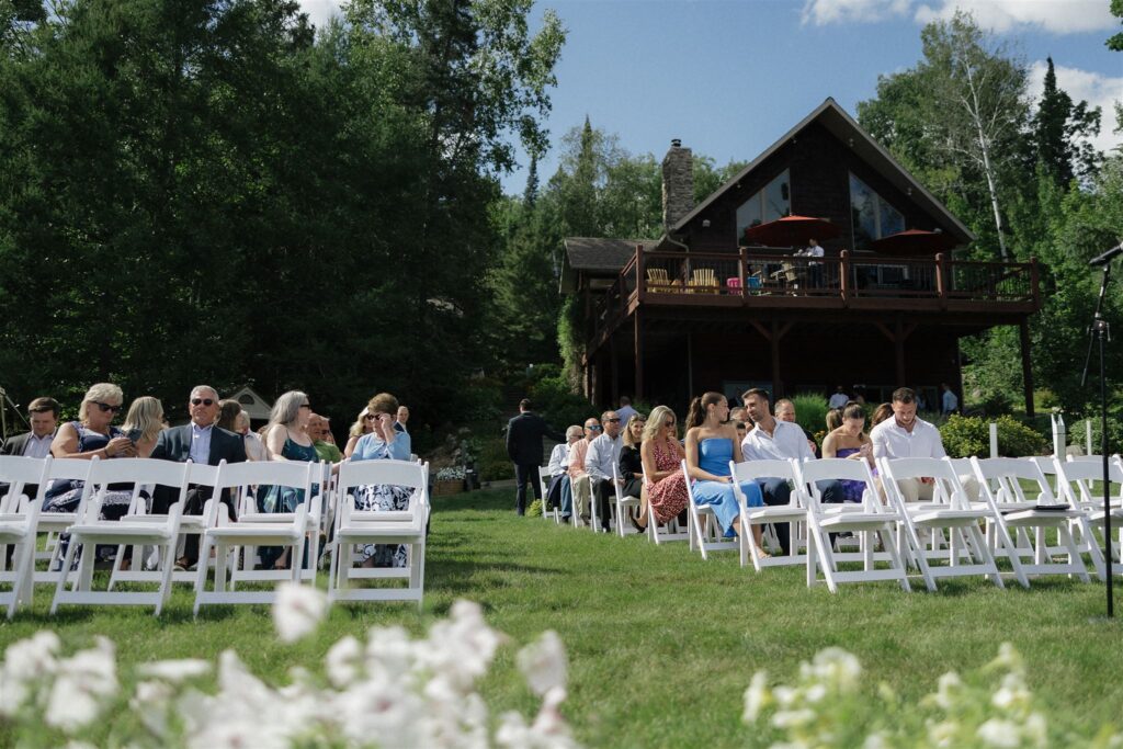 Guests wait outside A-frame cabin for wedding ceremony to begin