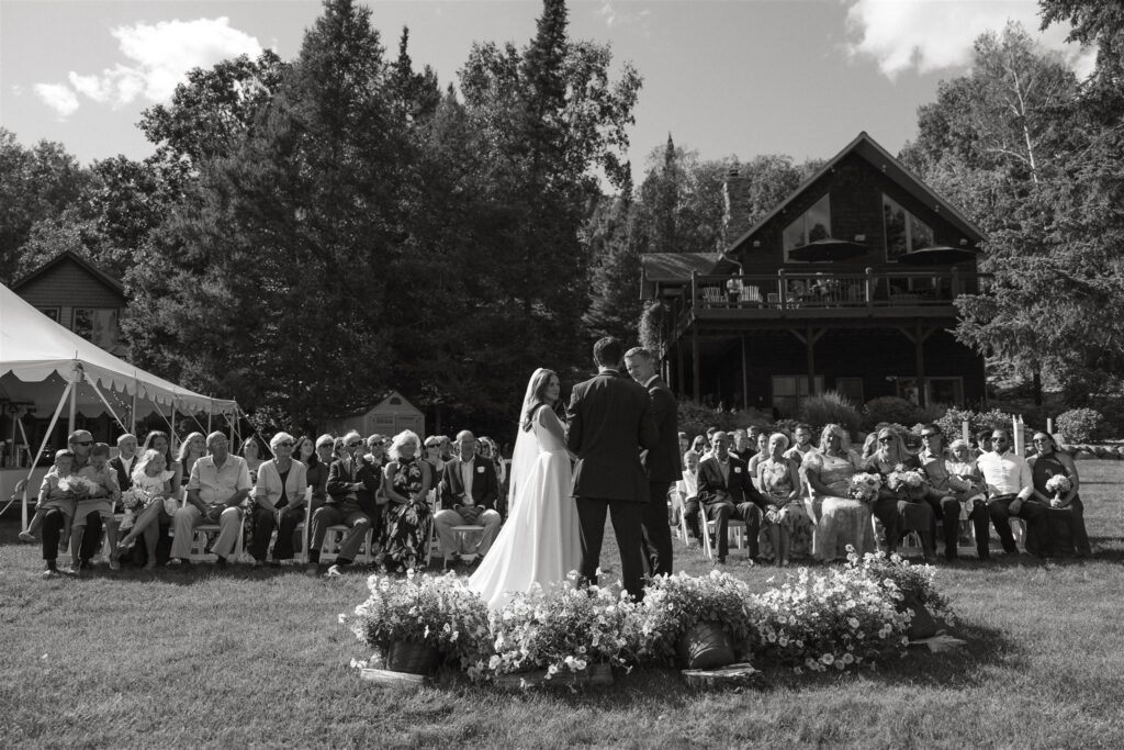 Bride and groom exchange their vows as wedding guests look adoringly on